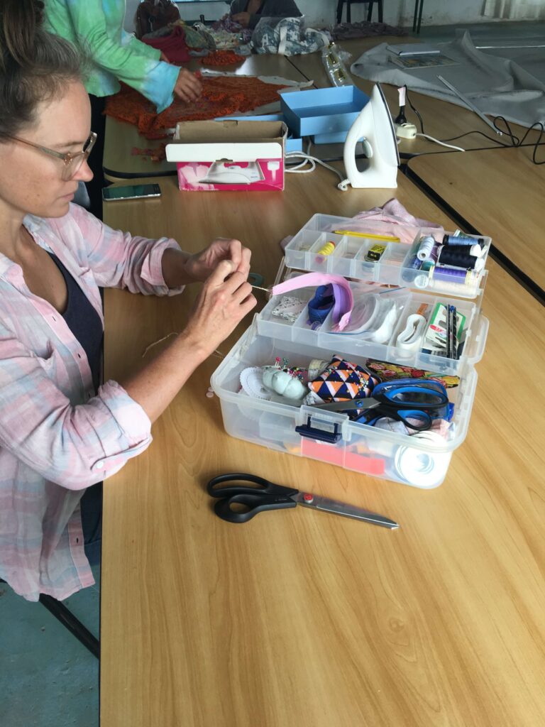 Image shows Sewists' Lab Owner, Madeleine, in sewing class. Making button loops by hand.